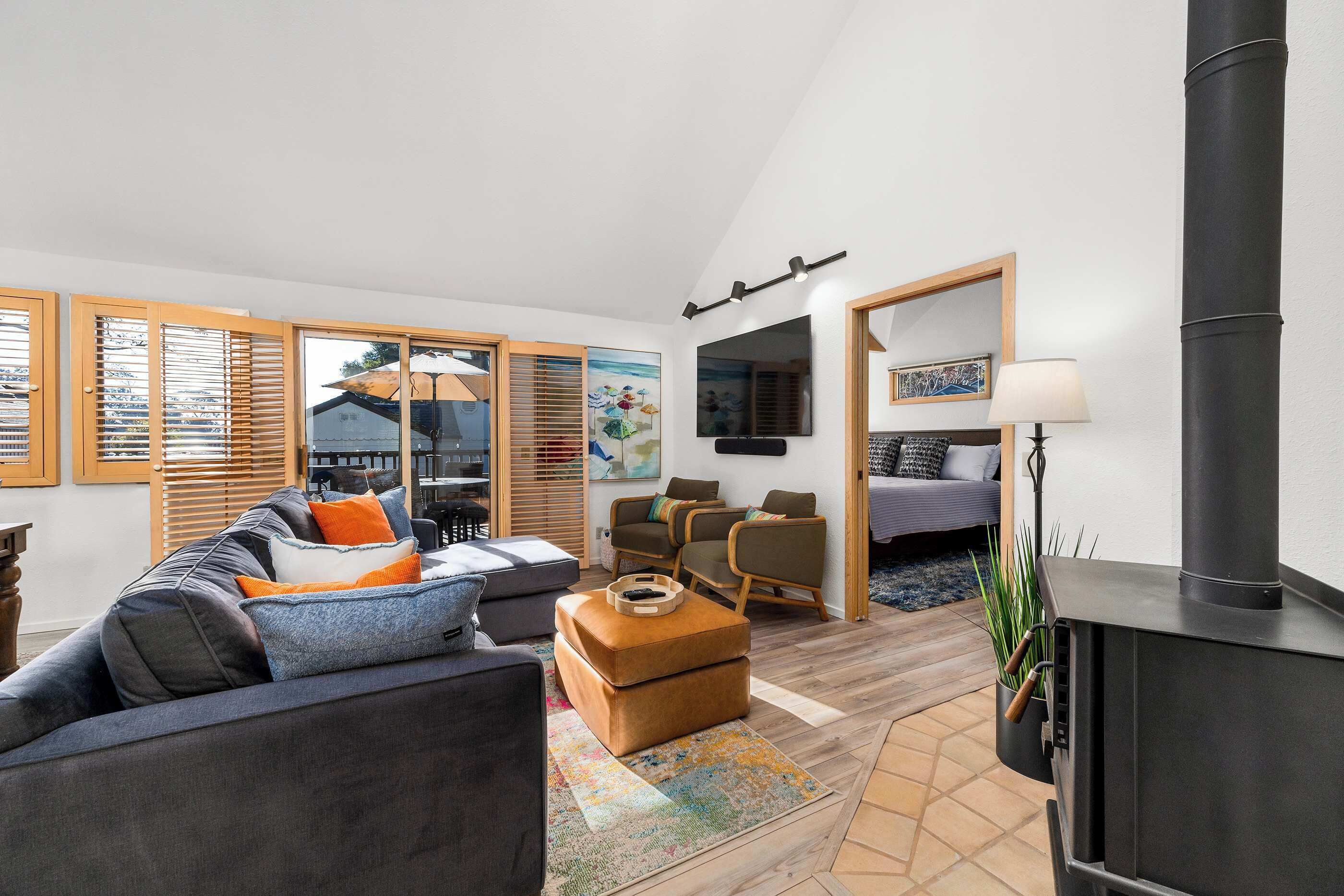 Una sala de estar moderna con sofá, sillones, chimenea y televisor.