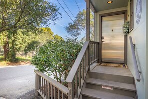 A wooden staircase leading to a door with a welcome mat, surrounded by greenery. - Relaxing Getaway Overlooking Schwan Lagoon (Santa Cruz)