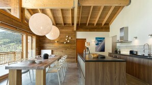 Una cocina moderna con una isla de madera, ventanas amplias y vistas al exterior.