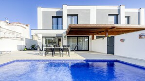 A modern two-story building with a swimming pool, outdoor seating, and a covered patio area. - Mon Petit Paradis by Interhome (Empuriabrava)