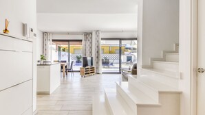 A modern interior with a kitchen, dining area, and a staircase leading to another level. - Mon Petit Paradis by Interhome (Empuriabrava)