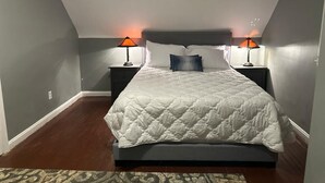 A bedroom with a large bed, two bedside lamps, and a patterned rug. - Charming 2-bedroom in serene Capitol Heights near Washington DC (Capitol Heights)