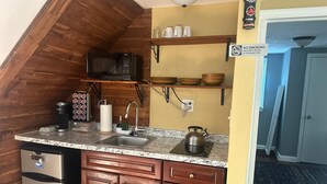 A compact kitchen with a microwave, coffee maker, kettle, and wooden cabinets. - Charming 2-bedroom in serene Capitol Heights near Washington DC (Capitol Heights)