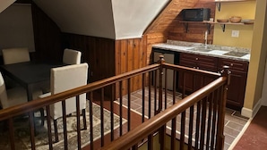 A kitchen with wooden cabinets, a granite countertop, and a microwave. - Charming 2-bedroom in serene Capitol Heights near Washington DC (Capitol Heights)