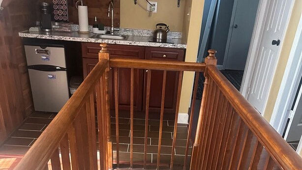 A kitchen with wooden cabinets, a stainless steel refrigerator, and a granite countertop. - Charming 2-bedroom in serene Capitol Heights near Washington DC (Capitol Heights)