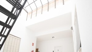 A spacious interior with a high ceiling, a skylight, a fire extinguisher, and a door marked with the number 6.