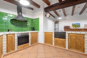 Une cuisine équipée d’une cuisinière, d’un four et d’un plan de travail recouvert de carreaux verts.