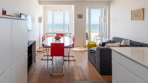 Un espace de vie moderne comprenant un coin repas, un canapé et une vue sur la plage.