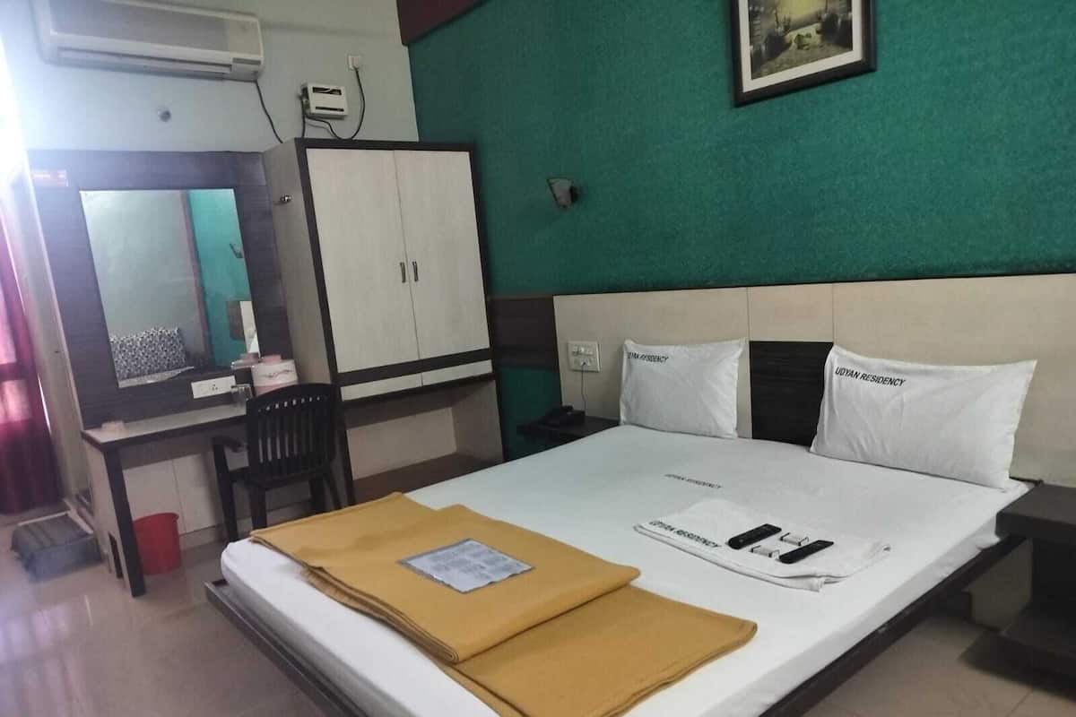 A hotel room with a bed, a desk, and a wardrobe.