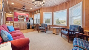 A cozy cabin interior with a living room, dining area, and kitchen.