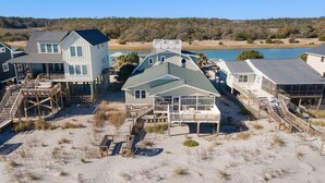 A beachfront property with multiple houses connected by walkways, overlooking a lake.
