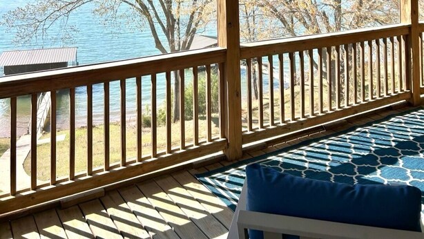 A covered outdoor deck with a view of a lake and trees. - Spacious 5-bedroom lakefront house in Anderson, 13 miles to Clemson (Anderson)