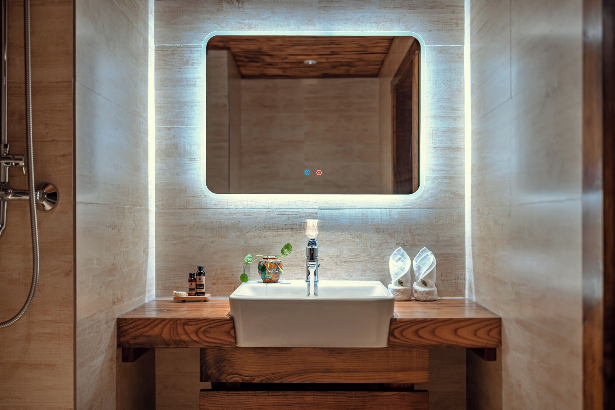 A modern bathroom with a wooden vanity, a rectangular sink, and a mirror above it.