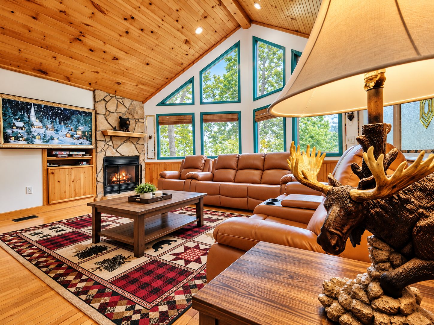 A cozy living room with a fireplace, leather sofa, and a large window.