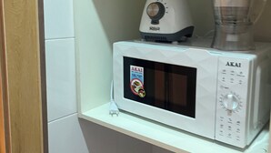 A microwave and blender on a white shelf in a kitchen with purple cabinets. - Private, Cozy, CityCentre Studio Apartment in the heart of Abuja (Abuja)