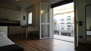 Eine moderne Wohnung mit Küche, Essbereich und einem Balkon mit Stadtblick.