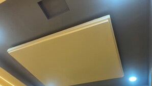 Een plafond met inbouwspots en een centraal hanglamp.