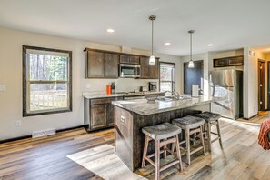 A modern kitchen with a large island, stainless steel appliances, and a view of the outdoors. - Golf, Hike & Boat: Home w/ Fire Pit in Friendship (Friendship)