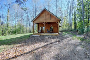 A wooden cabin with a porch, surrounded by a forest. - Secluded Cabin w/ Dock Access in Pittsville (Pittsville)