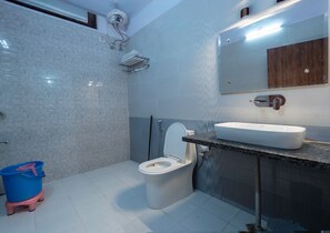 Uma casa de banho moderna com sanita, lavatório e chuveiro.