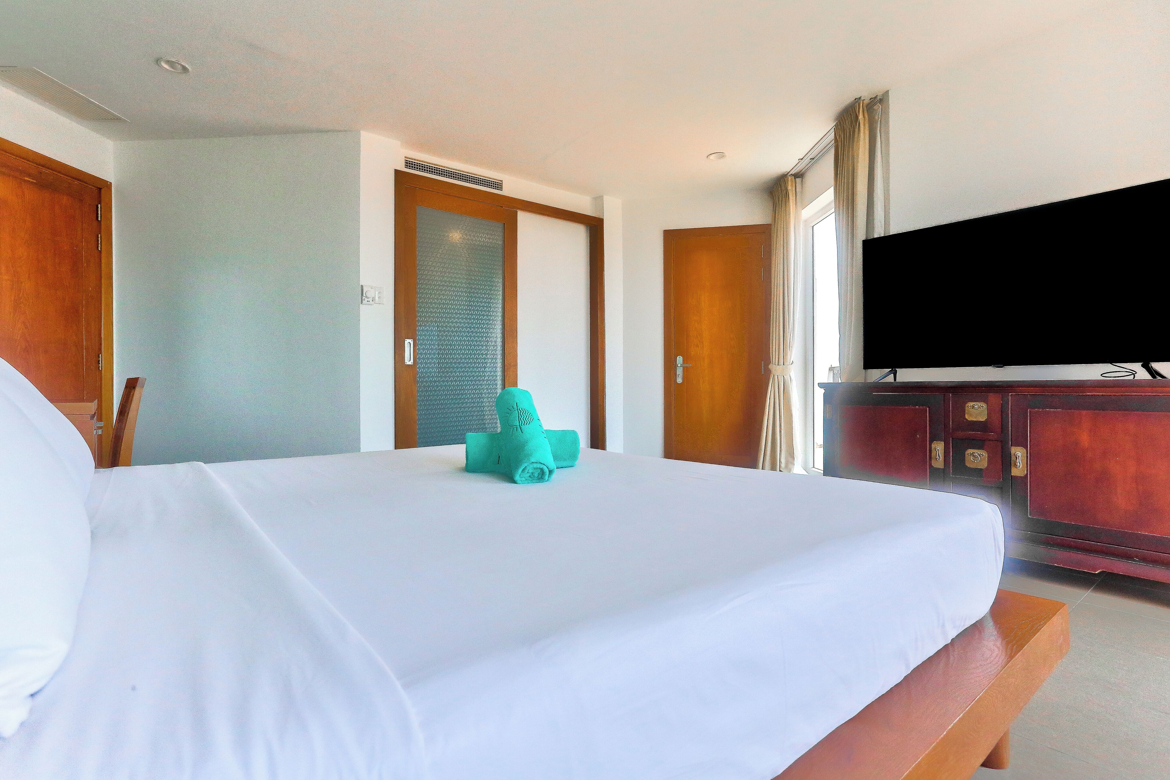 Una habitación de hotel con una cama, un televisor y un armario de madera.