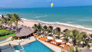 Kursi berjemur, payung pantai, dan voli pantai