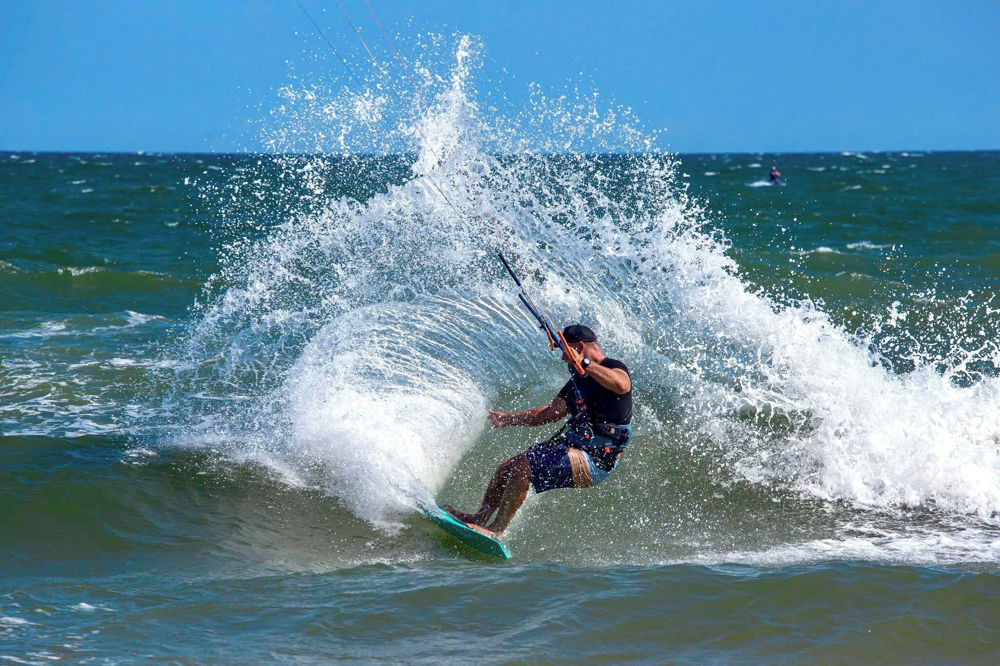 A person windsurfing on a wave.