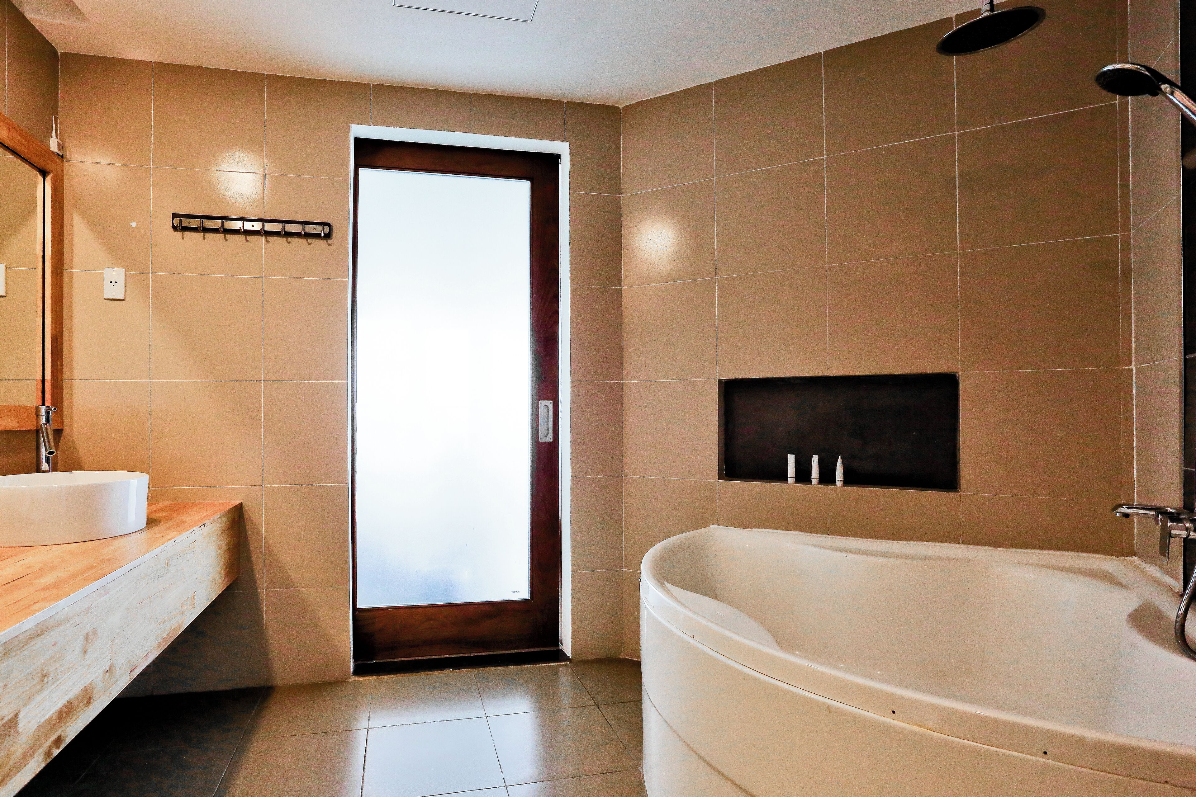 A modern bathroom with a wooden vanity, a large bathtub, and a shower.