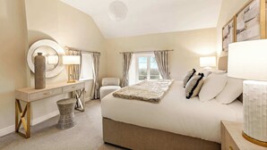 A bedroom with a bed, bedside tables, a mirror, and a window. - Great Easton Lodge (Great Easton)