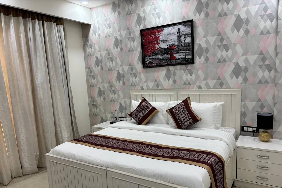 A neatly arranged bedroom with a bed, pillows, a bedside table, and a wall-mounted picture.