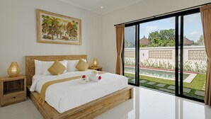 Camera da letto con un grande letto, una testiera in legno e vista su un giardino tramite una porta scorrevole in vetro.