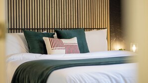 A neatly made bed with white linens and green pillows, a black headboard, and a bedside table with a lamp. - Game Room - Hot Tub - Fire Pit - 25 min 2 Yosemite
EV Charger Level 2 (Oakhurst)