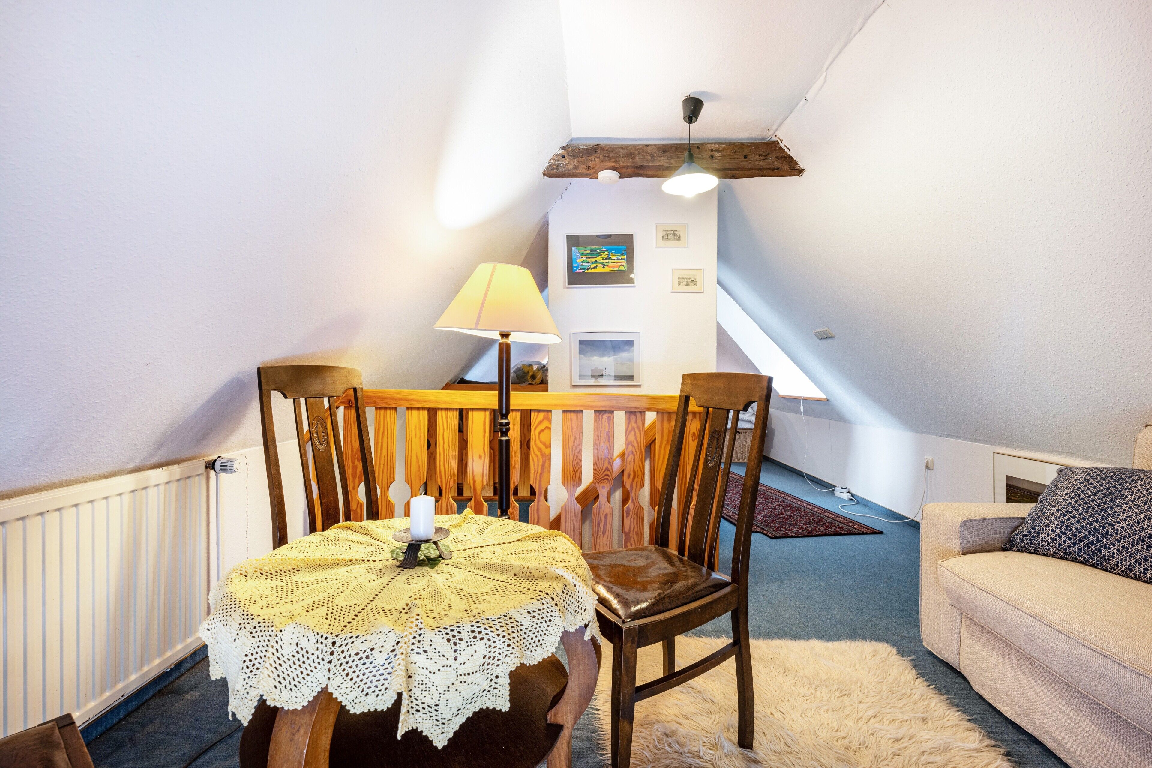 A cozy room with a dining table, chairs, a sofa, and a ceiling fan.