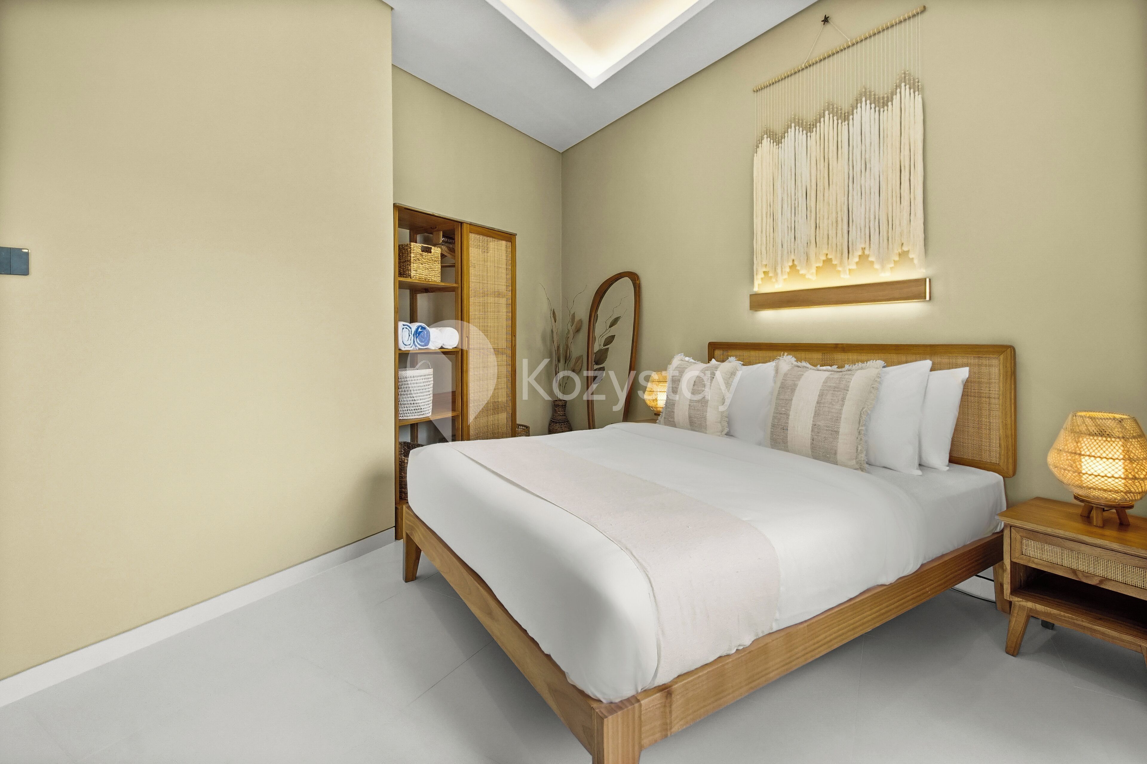 A bedroom with a wooden bed, bedside table, and wall-mounted lamp.
