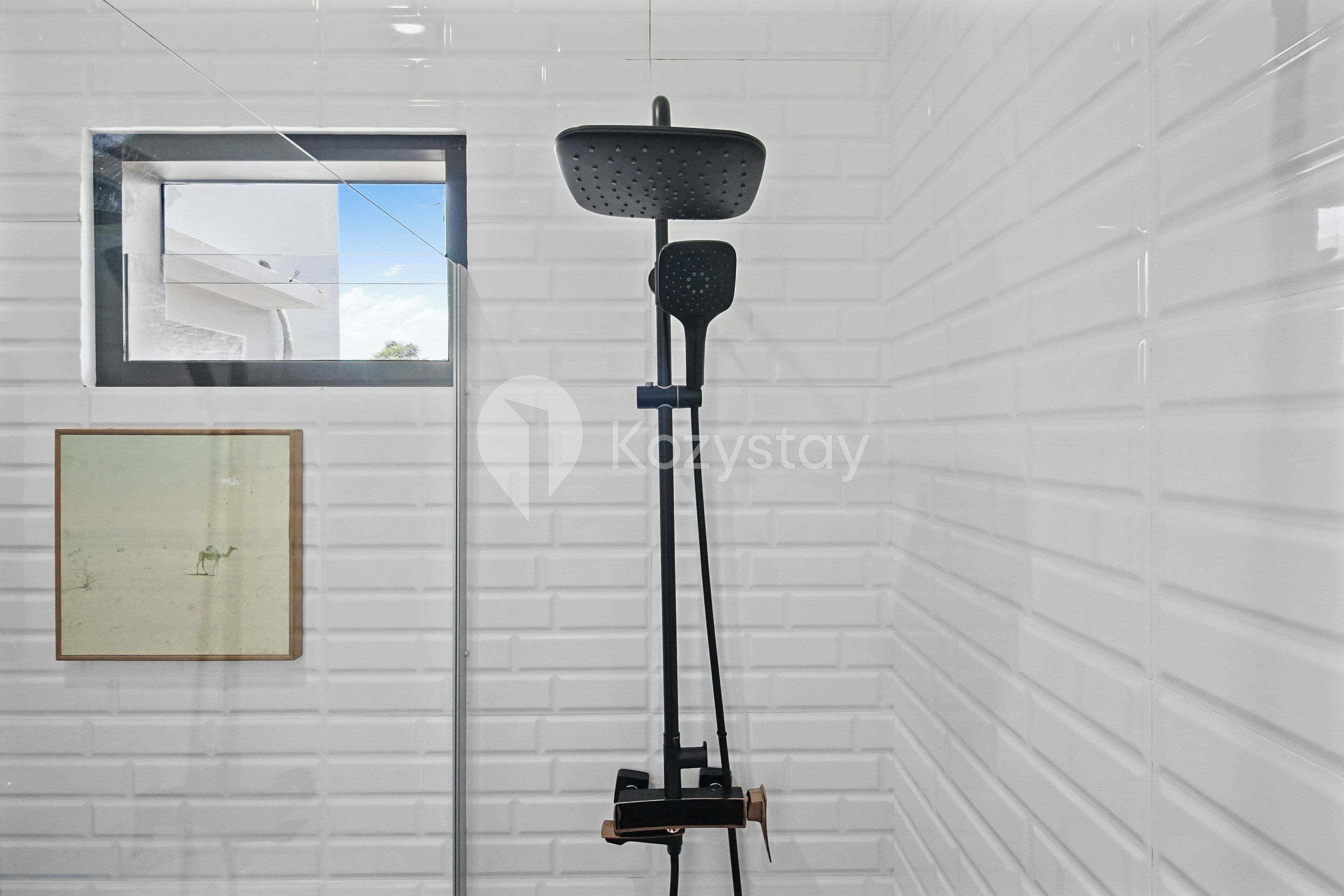 Una habitación con pared de ladrillo blanco, un cuadro enmarcado y una lámpara de pie.