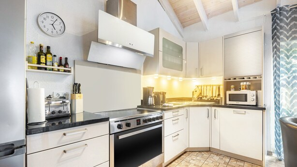 A kitchen with a stove, oven, microwave, and various kitchen appliances. - Holiday Home 'Enztal' with Shared Terrace (Zweifelscheid)