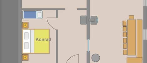 Distribución de una habitación de hotel con cama, baño, kitchenette y un pequeño rincón de descanso.