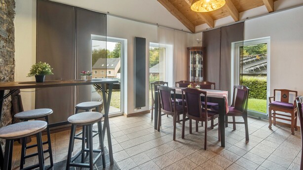 A modern kitchen with a dining area, large windows, and a wooden ceiling. - Holiday Home 'Eifellandhaus' with Shared Terrace and Wi-Fi (Zweifelscheid)