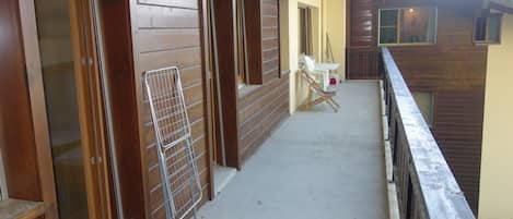 Un espace extérieur abrité, doté de murs en bois, de rampes en métal et d’un sol en béton.
