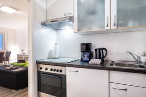 Una cocina moderna con estufa, horno y cafetera.