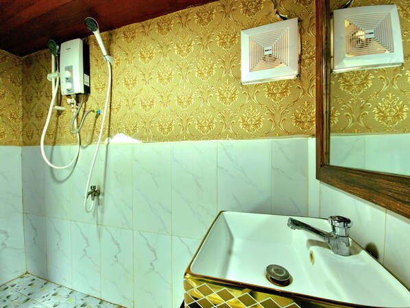 Un baño con lavamanos blanco, espejo y ducha.
