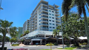 Un hotel de varios pisos con balcones, un restaurante llamado "Villa Romana" y un letrero que dice "Yaya's Hellonic Kitchen & Bar".