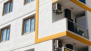 A multi-story building with balconies, air conditioning units, and a sign indicating directions to Forum Plus, Kuyumculuk, and Konaklama. - pozcu forum plus (Mersin)