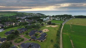 An aerial view of a residential area with houses, a park, and a road leading to the sea. - Normandie Veules-les-roses, Terraced House (Veules-les-Roses)