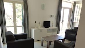 A living room with two sofas, a TV, a lamp, and a cabinet.