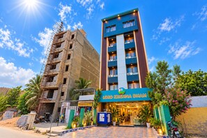 A hotel named 'Lord Krishna Dam' with a modern facade, a well-maintained entrance, and a clear sky. - Hotel Lord Krishna Dham (Dwarka)