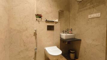 A bathroom with a toilet, sink, and shower.