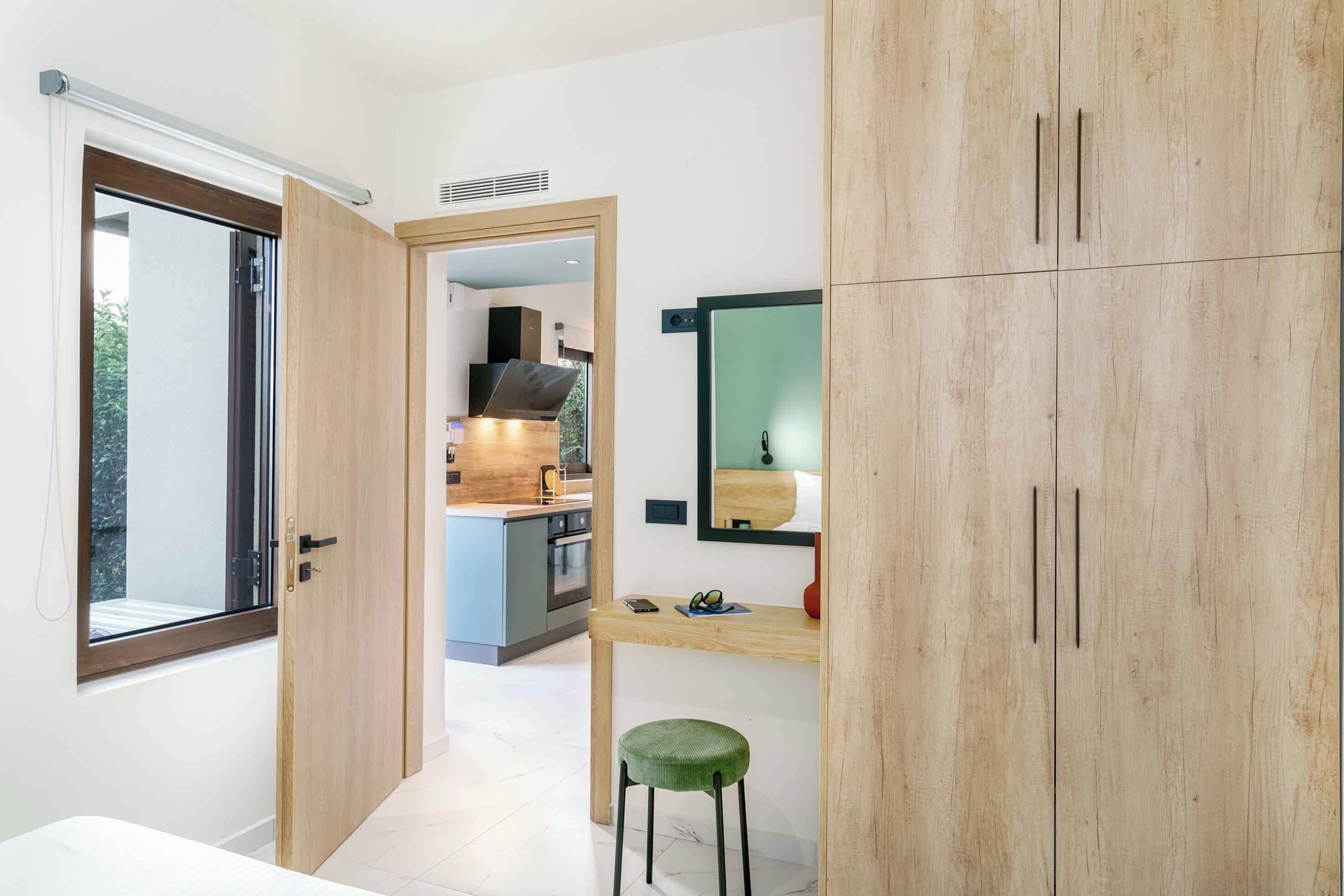 Ein modernes Badezimmer mit einem Holzlagerflansch, einem Spiegel und einem grünen Hocker.