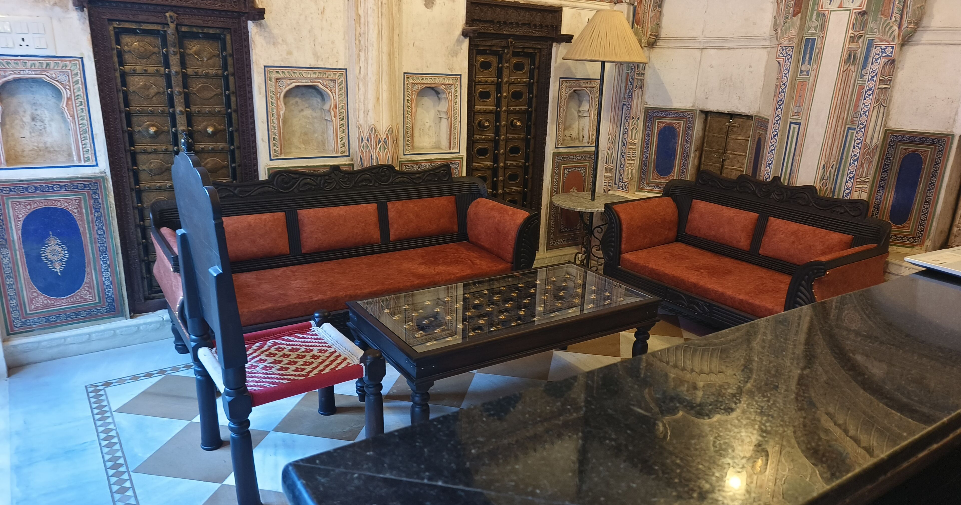 A traditional room with a sofa set, a small table, and a chair.