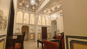 A room with ornate ceiling designs, a wooden door, and a mirror. - HOTEL MANDAWA VILAS (Jhunjhunu)